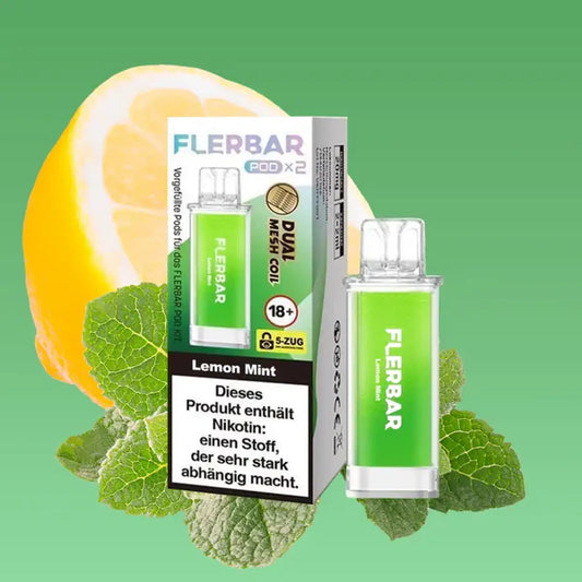Ein hellgrüner Flerbar Pod in der Sorte Lemon Mint steht neben seiner Verpackung, umgeben von einer frischen halben Zitrone und Minzblättern auf grünem Hintergrund.
