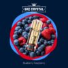 Der SKE Crystal Plus Pod in der Sorte Blueberry Raspberry – stilvoller, goldfarbener Pod vor einem intensiven Hintergrund aus reifen Blaubeeren und saftigen Himbeeren. Perfekter Fruchtmix mit 20 mg/ml Nikotinsalz für bis zu 600 Züge im nachfüllbaren Pod-System.